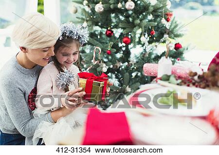 Picture - Smiling mother and daughter with Christmas gift. Fotosearch