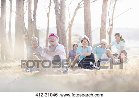 Smiling senior adults practicing yoga in sunny park View Large Photo Image Stock Photograph - Smiling senior adults practicing yoga in sunny park. Fotosearch