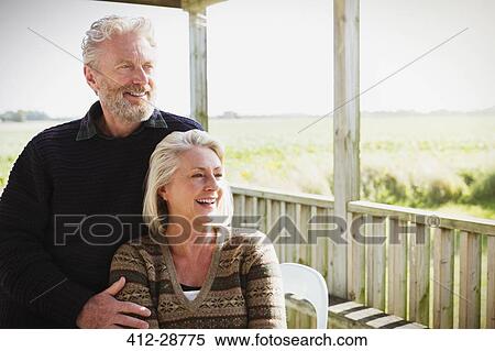 Smiling senior couple looking away on sunny porch View Large Photo Image Stock Photography - Smiling senior couple looking away on sunny porch. Fotosearch