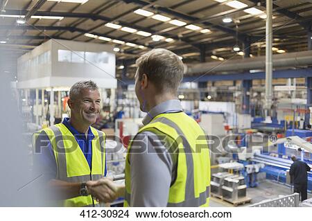Smiling supervisor and worker handshaking in steel factory View Large Photo Image Picture - Smiling supervisor and worker handshaking in steel factory. Fotosearch