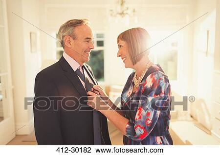 Smiling wife tying husbands tie View Large Photo Image Stock Image - Smiling wife tying husbands tie. Fotosearch