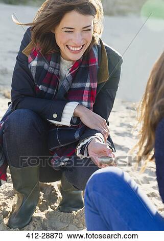 Smiling woman clamming on beach View Large Photo Image Stock Image - Smiling woman clamming on beach. Fotosearch