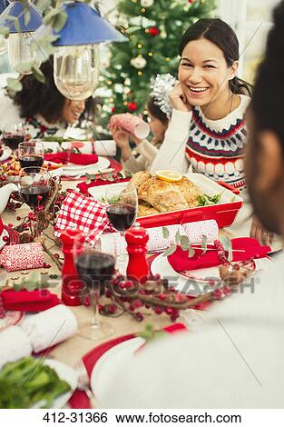 Stock Photograph - Smiling woman enjoying Christmas dinner. Fotosearch