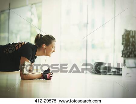 Smiling woman in plank position on gym studio floor View Large Photo Image Stock Photography - Smiling woman in plank position on gym studio floor. Fotosearch