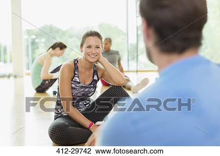Smiling woman talking to man at gym View Large Photo Image Stock Image - Smiling woman talking to man at gym. Fotosearch