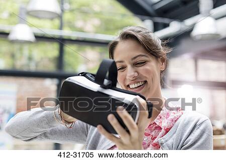 Smiling woman trying virtual reality simulator glasses at technology conference View Large Photo Image Stock Photography - Smiling woman trying virtual reality simulator glasses at technology conference. Fotosearch