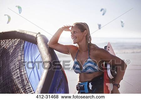 Smiling woman with kiteboard equipment on beach View Large Photo Image Stock Photo - Smiling woman with kiteboard equipment on beach. Fotosearch