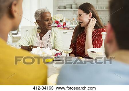 Stock Image - Smiling women enjoying party at table. Fotosearch
