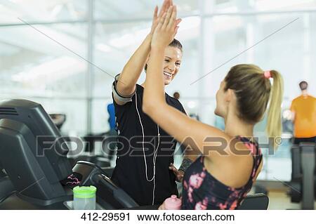 Smiling women high fiving at gym View Large Photo Image Stock Image - Smiling women high fiving at gym. Fotosearch