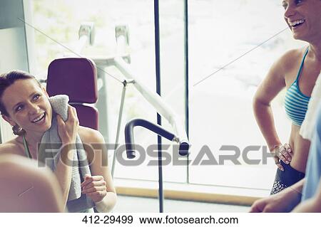 Smiling women resting and talking at gym View Large Photo Image Stock Photo - Smiling women resting and talking at gym. Fotosearch