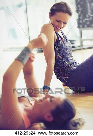 Smiling women resting on gym studio floor View Large Photo Image Picture - Smiling women resting on gym studio floor. Fotosearch