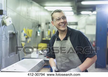 Picture - Smiling worker in steel factory. Fotosearch
