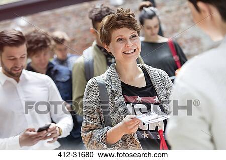 Smiling young woman showing credentials at technology conference View Large Photo Image Stock Image - Smiling young woman showing credentials at technology conference. Fotosearch