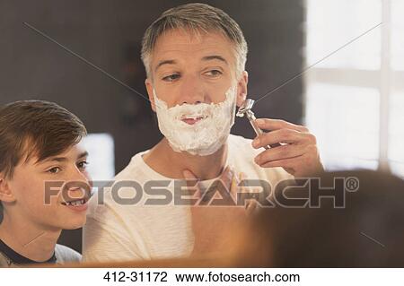 Son watching father shave face in bathroom mirror View Large Photo Image Stock Image - Son watching father shave face in bathroom mirror. Fotosearch