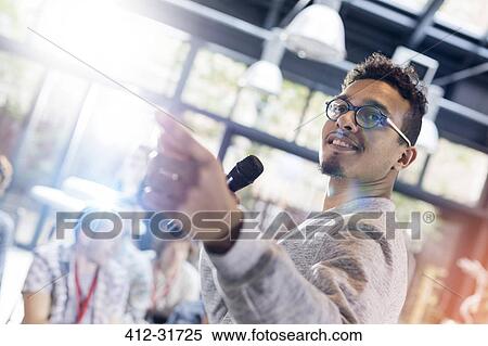 Speaker with microphone leading presentation at conference View Large Photo Image Stock Photography - Speaker with microphone leading presentation at conference. Fotosearch