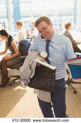 Stock Image - Stressed businessman struggling to multitask in office. Fotosearch