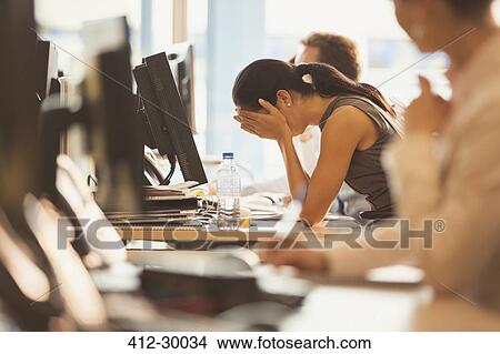 Stressed businesswoman with head in hands at office desk View Large Photo Image Picture - Stressed businesswoman with head in hands at office desk. Fotosearch