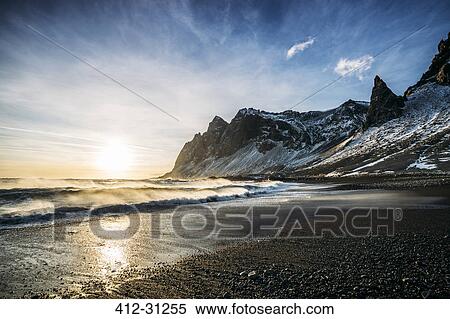 Sun setting over tranquil beach and snowy mountain, Iceland View Large Photo Image Stock Photography - Sun setting over tranquil beach and snowy mountain, Iceland. Fotosearch