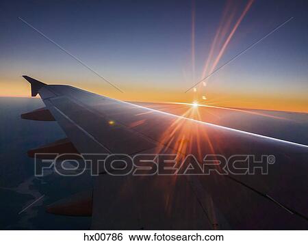 Sunset behind airplane wing in sky View Large Photo Image Stock Photograph - Sunset behind airplane wing in sky. Fotosearch