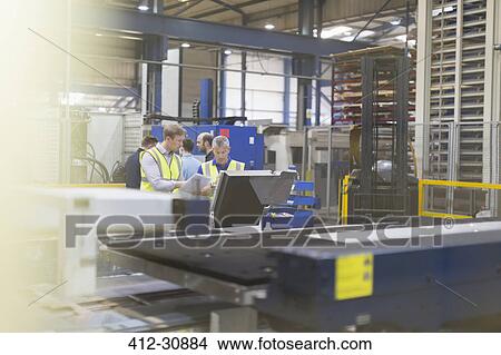 Picture - Supervisor and workers in steel factory. Fotosearch
