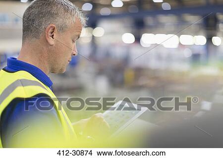 Picture - Supervisor using digital tablet in steel factory. Fotosearch