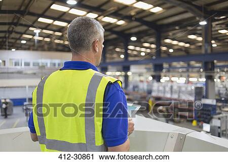 Supervisor with clipboard in steel factory View Large Photo Image Stock Image - Supervisor with clipboard in steel factory. Fotosearch