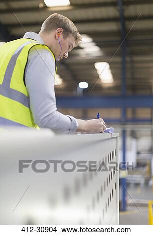 Supervisor writing on clipboard in steel factory View Large Photo Image Picture - Supervisor writing on clipboard in steel factory. Fotosearch