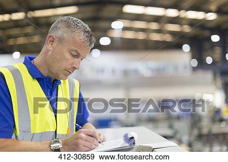 Supervisor writing on clipboard in steel factory View Large Photo Image Stock Photo - Supervisor writing on clipboard in steel factory. Fotosearch