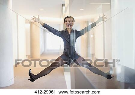 Symmetrical reflection portrait of playful businesswoman with arms and legs apart in office corridor View Large Photo Image Stock Image - Symmetrical reflection portrait of playful businesswoman with arms and legs apart in office corridor. Fotosearch