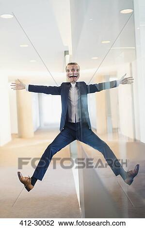 Symmetrical reflection portrait of businessman with arms and legs outstretched in office corridor View Large Photo Image Stock Image - Symmetrical reflection portrait of businessman with arms and legs outstretched in office corridor. Fotosearch