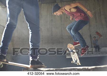 Teenage boy flipping skateboard at skate park View Large Photo Image Picture - Teenage boy flipping skateboard at skate park. Fotosearch
