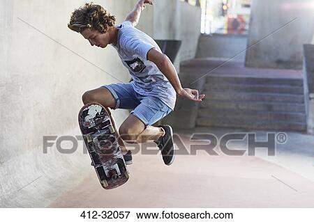 Teenage boy flipping skateboard at skate park View Large Photo Image Stock Photo - Teenage boy flipping skateboard at skate park. Fotosearch