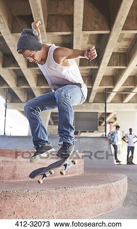 Teenage boy jumping skateboard at skate park View Large Photo Image Stock Image - Teenage boy jumping skateboard at skate park. Fotosearch
