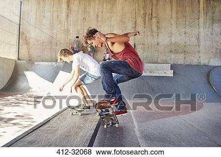 Teenage boys skateboarding at skate park View Large Photo Image Stock Photo - Teenage boys skateboarding at skate park. Fotosearch