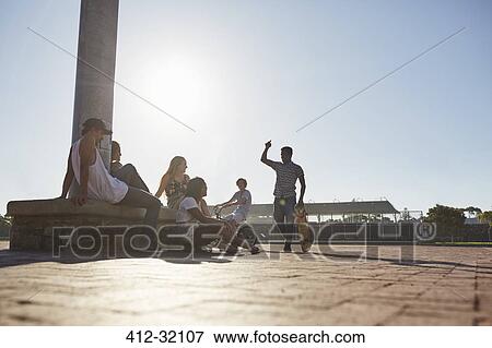 Teenage friends hanging out at sunny skate park View Large Photo Image Stock Photo - Teenage friends hanging out at sunny skate park. Fotosearch