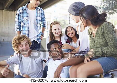 Teenage friends hanging out talking at skate park View Large Photo Image Stock Photograph - Teenage friends hanging out talking at skate park. Fotosearch