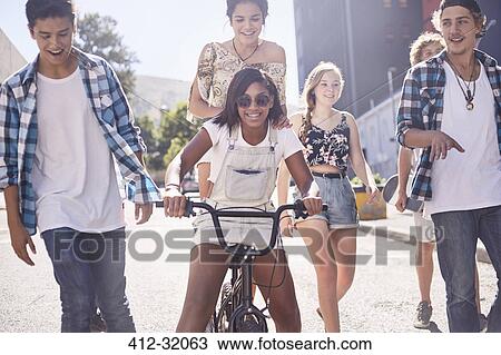 Teenage friends with BMX bicycle on sunny urban street View Large Photo Image Stock Image - Teenage friends with BMX bicycle on sunny urban street. Fotosearch