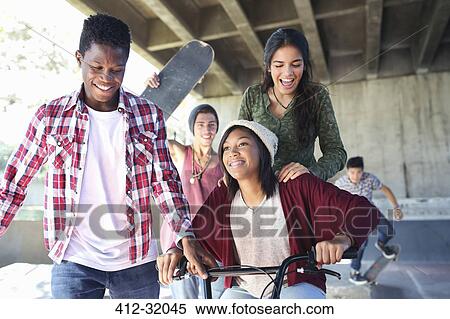 Teenage friends with skateboards and BMX bicycle at skate park View Large Photo Image Stock Photography - Teenage friends with skateboards and BMX bicycle at skate park. Fotosearch