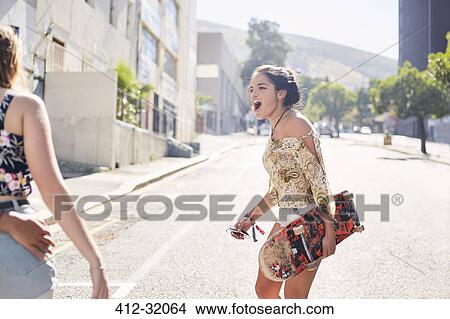 Teenage girl with skateboard on sunny urban street View Large Photo Image Picture - Teenage girl with skateboard on sunny urban street. Fotosearch