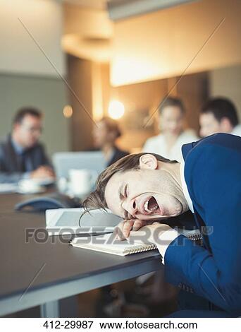 Tired businessman yawning and laying on conference table View Large Photo Image Stock Photo - Tired businessman yawning and laying on conference table. Fotosearch