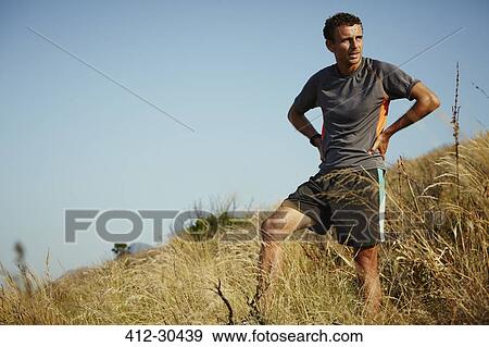 Tired runner taking a break on grassy trail View Large Photo Image Stock Photo - Tired runner taking a break on grassy trail. Fotosearch