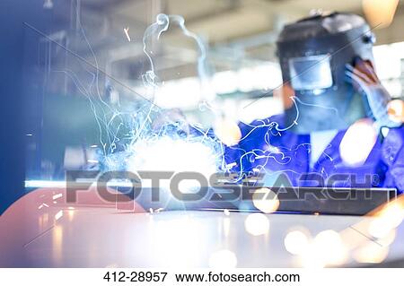 Stock Photo - Welder using welding torch in factory. Fotosearch