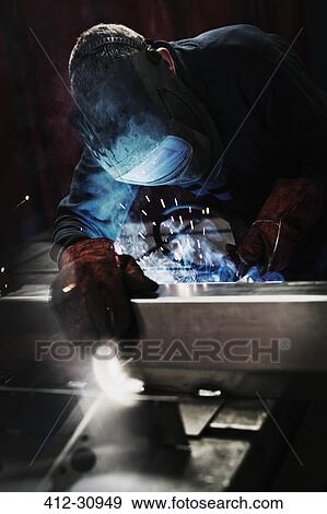 Welder using welding torch in steel factory View Large Photo Image Stock Photo - Welder using welding torch in steel factory. Fotosearch