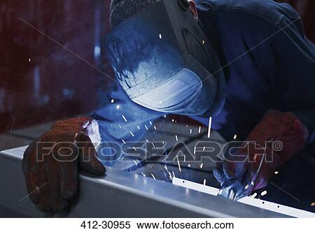 Stock Photography - Welder using welding torch in steel factory. Fotosearch