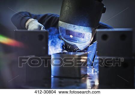 Picture - Welder using welding torch on part in steel factory. Fotosearch
