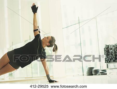 Woman balancing in side plank in gym studio View Large Photo Image Stock Photography - Woman balancing in side plank in gym studio. Fotosearch