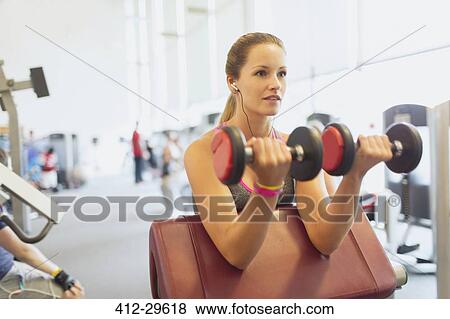 Woman doing dumbbell biceps curls at gym View Large Photo Image Stock Photo - Woman doing dumbbell biceps curls at gym. Fotosearch