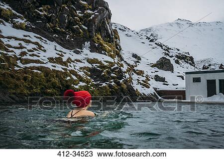 Woman in stocking cap swimming below snowy mountains, Iceland View Large Photo Image Stock Image - Woman in stocking cap swimming below snowy mountains, Iceland. Fotosearch