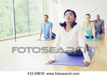 Woman in upward facing dog position in yoga class View Large Photo Image Stock Photograph - Woman in upward facing dog position in yoga class. Fotosearch