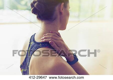 Woman rubbing neck at gym View Large Photo Image Stock Photo - Woman rubbing neck at gym. Fotosearch